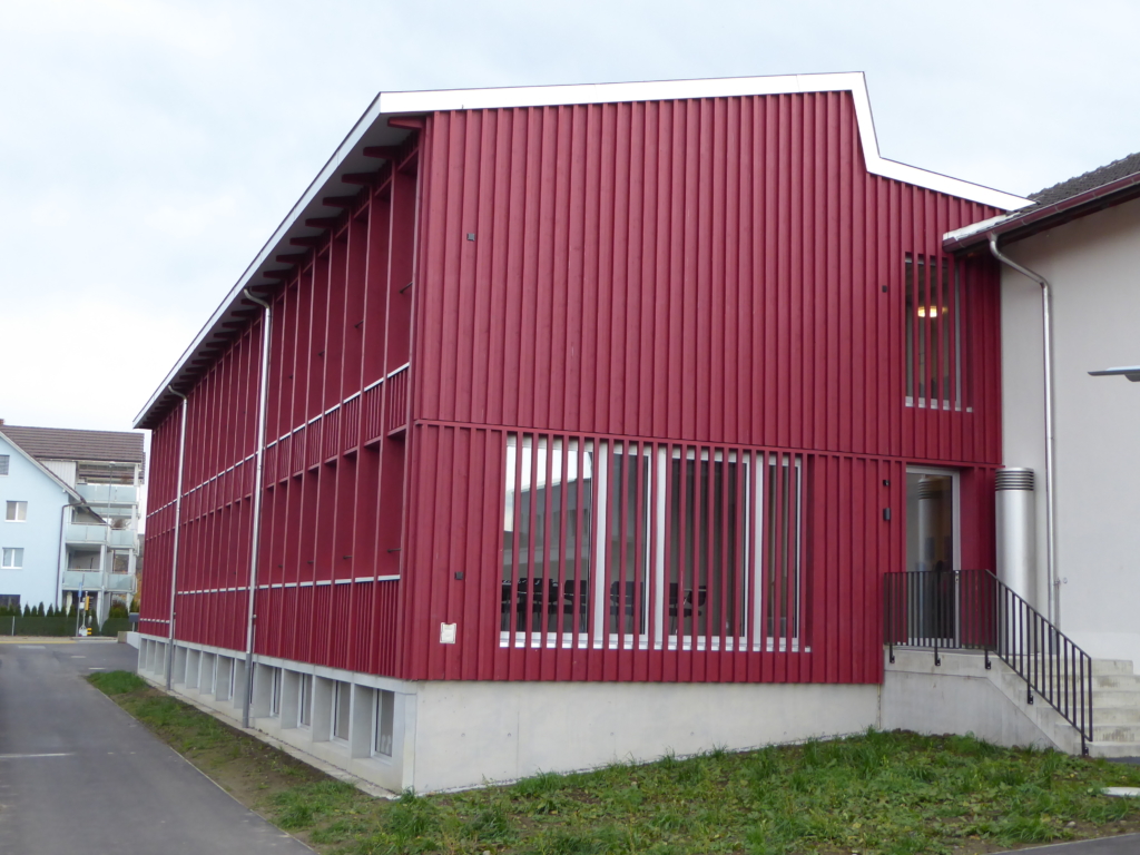 Farbenfroh mit Durchblick: Schulhaus-Anbau Scherzingen mit Fassade aus Schweizer Holz (behandelte Fichte) | Krattiger Holzbau AG Amriswil