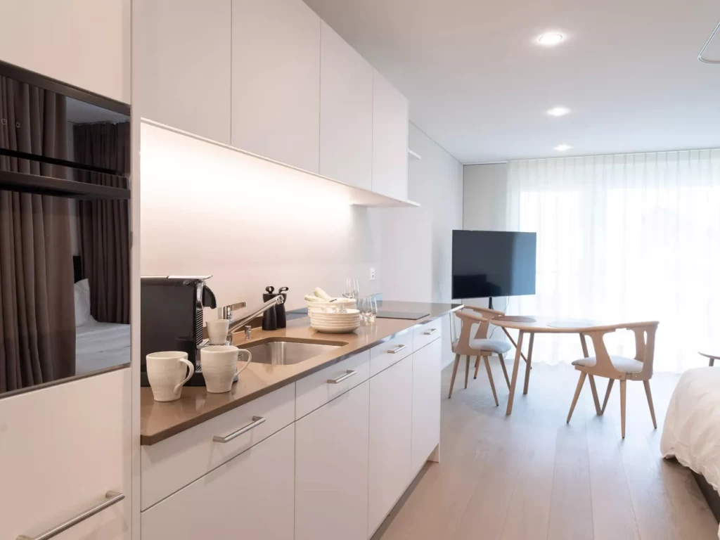 Wohnraum und Küchenzeile eines UNUS-Apartments in St. Gallen komplett aus heimeligem Holz